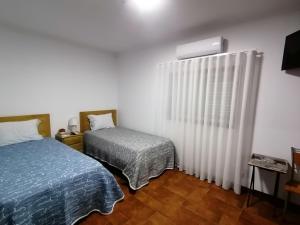 a bedroom with two beds and a radiator at Hostel Encostas Do Douro in Marco de Canaveses