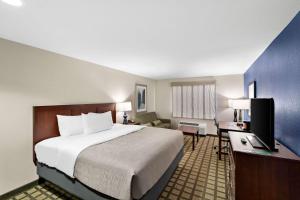 a bedroom with a bed and a desk with a television at Quality Inn & Suites in Big Spring