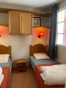 1 Schlafzimmer mit 2 Betten, einem Fenster und Schränken in der Unterkunft Appartement 4 pers1 chb Résidence du Lac vue sur les bois in Monflanquin