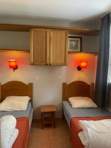 2 Betten in einem Zimmer mit orangefarbenen Wänden und Schränken in der Unterkunft Appartement 4 pers1 chb Résidence du Lac vue sur les bois in Monflanquin