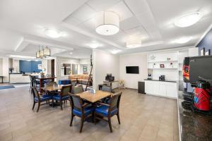 a dining room with tables and chairs and a kitchen at Quality Inn & Suites Big Spring in Big Spring