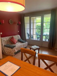 a living room with a couch and a table at Appartement 4 pers1 chb Résidence du Lac vue sur les bois in Monflanquin