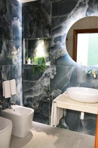ein Bad mit einem Waschbecken und einem Spiegel in der Unterkunft B&B Le Ortensie in San Vito lo Capo