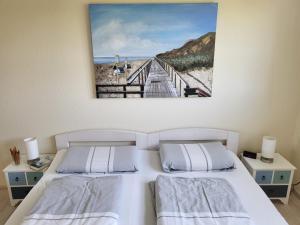 um quarto com duas camas e um quadro na parede em Ferienhaus DHH "Unsere zweite Heimat" links em Sankt Peter-Ording