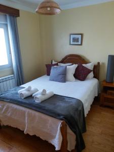 a bedroom with a bed with two towels on it at Casas do Castelo in Aldeia da Serra