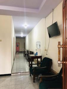 - un couloir avec des chaises et une télévision murale dans l'établissement CELLINO HOMESTAY, à Probolinggo