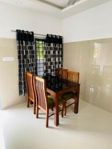 een eetkamer met een tafel en stoelen bij Asian Nest Serviced Apartments in Cochin