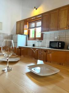 a wooden table with a plate and a wine glass at Panos Villas in Koukounaries