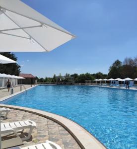 a large swimming pool with chairs and an umbrella at Xəzər İstirahət Mərkəzi in Bunud
