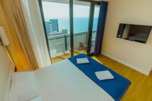 Sea View Panoramic Suite Orbi City في باتومي: غرفة فندقية بسرير ونافذة كبيرة