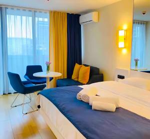 バトゥミにあるSea View Panoramic Suite Orbi Cityのベッド2台、テーブルと椅子が備わるホテルルームです。