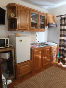 a kitchen with wooden cabinets and a white refrigerator at Casas do Castelo in Aldeia da Serra +72 photos