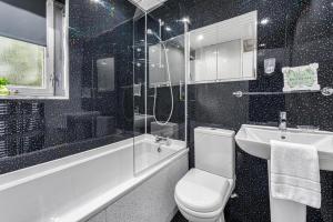 uma casa de banho com um WC, um lavatório e um chuveiro em Premier - Maryhill Apartment em Glasgow