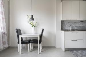 uma mesa branca com duas cadeiras e um vaso com flores em Live and Stay Lagerbring em Gotemburgo