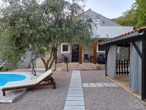 eine Terrasse mit einem Stuhl und einem Pool in der Unterkunft Holiday House Pulina in Punat