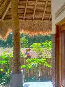 een uitzicht vanuit een huis met een palmboom bij Melody Surf Camp - Ekas Lombok in Ekas