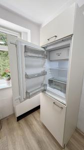 un réfrigérateur vide avec sa porte ouverte dans une cuisine dans l'établissement Berzi Ferienwohnung 2 Görlitz, à Görlitz