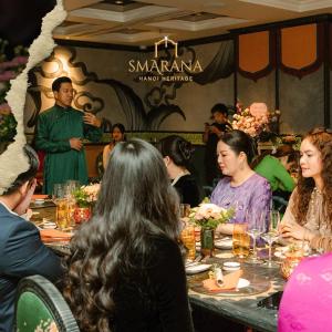 a group of people sitting at a table in a restaurant at Smarana Hanoi Heritage - Hotel and Retreats in Hanoi
