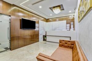 ein Wohnzimmer mit einem Sofa und einem Flachbild-TV in der Unterkunft Hotel Park Seven Near Delhi International Airport in Neu-Delhi