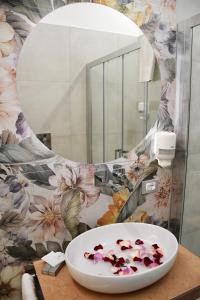 ein Badezimmer mit einem Waschbecken mit Blumen an der Wand in der Unterkunft B&B Le Ortensie in San Vito lo Capo