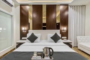 Hotel Park Seven Near Delhi International Airport في نيودلهي: غرفة في الفندق مع سرير مع غلاية شاي