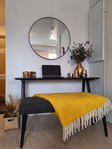 un tavolo con specchio e una panca con una coperta gialla di Ratalinna - free WiFi a Pori