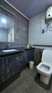 W łazience znajduje się toaleta, umywalka i lustro. w obiekcie The soiree w mieście Thiruvalla