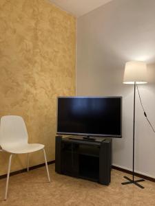 een woonkamer met een flatscreen-tv en een witte stoel bij Molino Nuovo in Vacallo