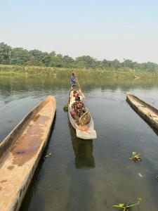 a group of people in a boat in the water at Hong Qi Hotel in Chitwan
