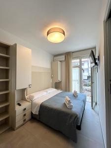 a bedroom with a bed and a window at Hotel Brigantino in Milano Marittima