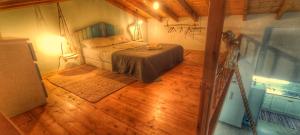 een slaapkamer met een bed en een houten vloer bij Merabello Beach House in Samos