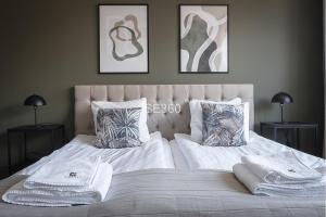 una camera con 2 letti con coperte e cuscini bianchi di Live and Stay VR40 a Göteborg