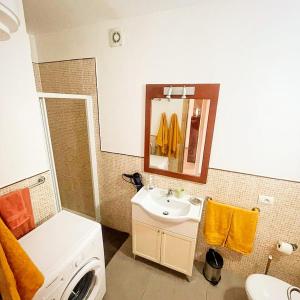a bathroom with a sink and a washing machine at Djadsal Moradias in Santa Maria