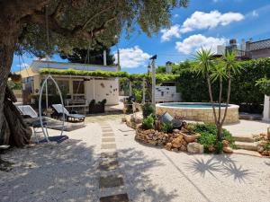 a backyard with a pool and a tree at Villa Anna Polignano in Polignano a Mare