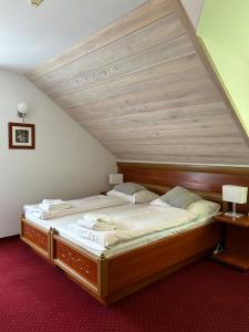 Cette chambre comprend un grand lit et un plafond en bois. dans l'établissement Hotel Promyk Wellness & Spa, à Karpacz