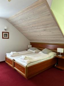 a large bed in a room with a wooden ceiling at Hotel Promyk Wellness & Spa in Karpacz