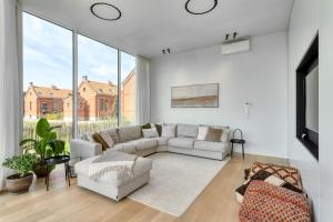 a living room with a couch and a tv at Aimé aan zee, villa te Oostende - Oosteroever met 2 parkeerplaatsen in Ostend