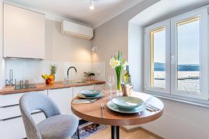 a kitchen with a wooden table and chairs and a kitchen with a window at Bella Vista in Cres
