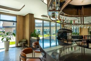 a bar in a restaurant with chairs and a chandelier at Novotel Tbilisi Center in Tbilisi City +41 photos