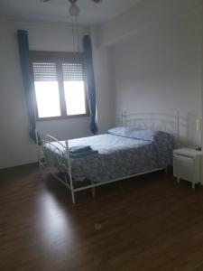 1 dormitorio con cama y ventana en OLEANDRI SUITE B&B, en Aprilia