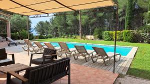 un patio con sillas y una piscina en Villa Eléonore, en Saint-Cyr-sur-Mer