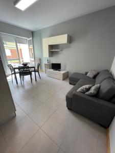 un soggiorno con un divano e un tavolo di Spring Apartment a Canelli