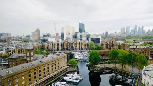 een uitzicht op een stad met boten in een rivier bij Specious en-suite room - a cosy homestay close to Tower Bridge in Londen