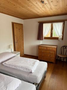 a bedroom with two beds and a wooden ceiling at Ferienwohnung Crameri in Klosters