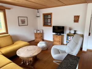 a living room with a couch and a table and a tv at Ferienwohnung Crameri in Klosters