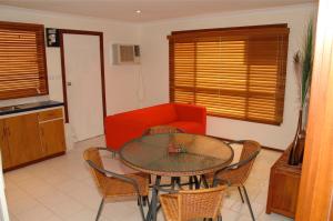 sala de estar con mesa, sillas y sofá rojo en Wildsights Beach Units, en Denham