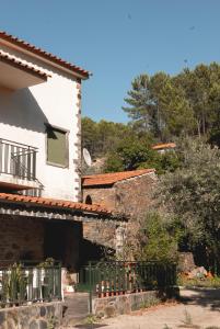 a white house with a fence next to it at Casa Penafalcão in Castelo Branco