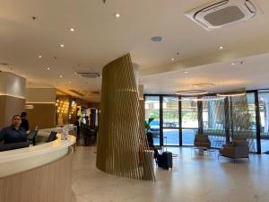 a lobby with a column in the middle of a building at Quarto em hotel pertinho do Aeroporto de Congonhas - H2208 in São Paulo +13 photos