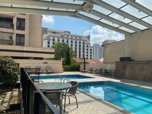 a patio with a table and a pool on a building at Quarto em hotel pertinho do Aeroporto de Congonhas - H2208 in São Paulo