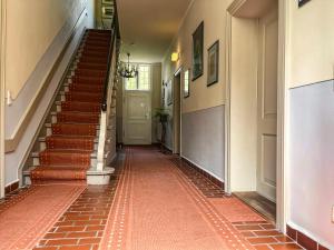 een hal met een rode tegelvloer en een trap bij Apartmenthaus Gutenberg 78 in Potsdam